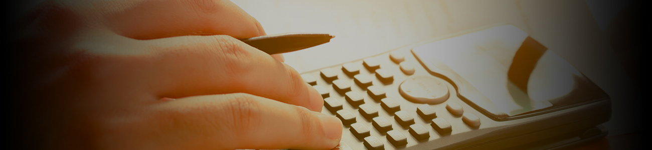 Close-up of hand using a calculator.